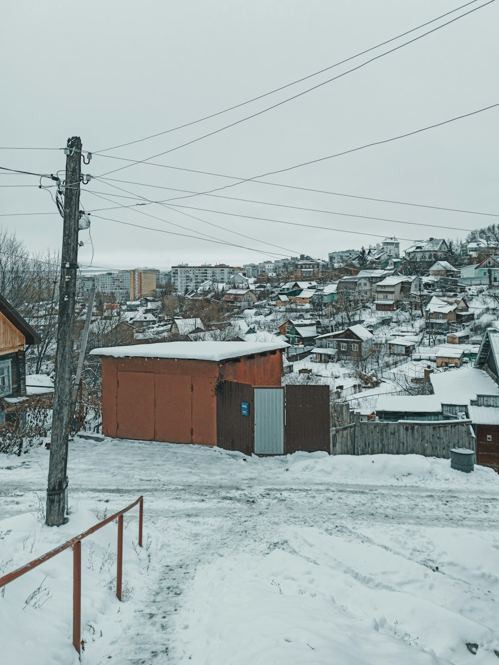 maison en bois brun recouverte de neige pendant la journée