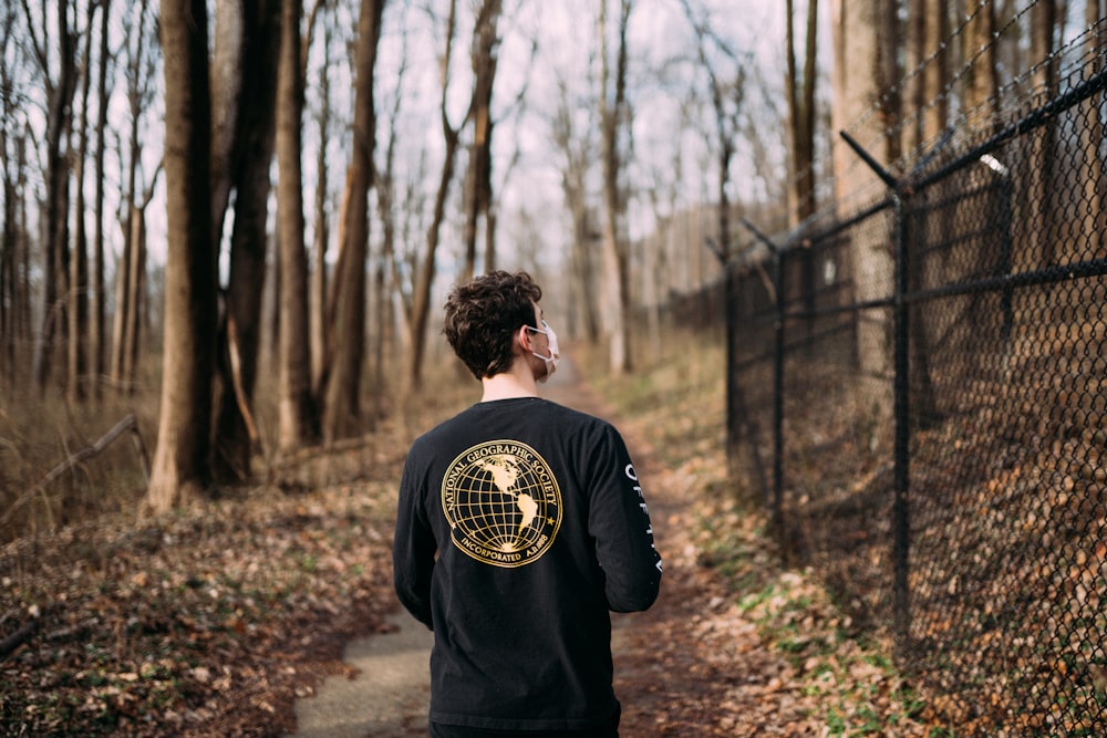 man in black long sleeve shirt holding gold and black soccer ball