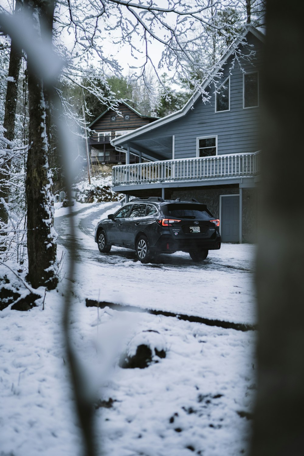 black suv parked near white wooden house during winter