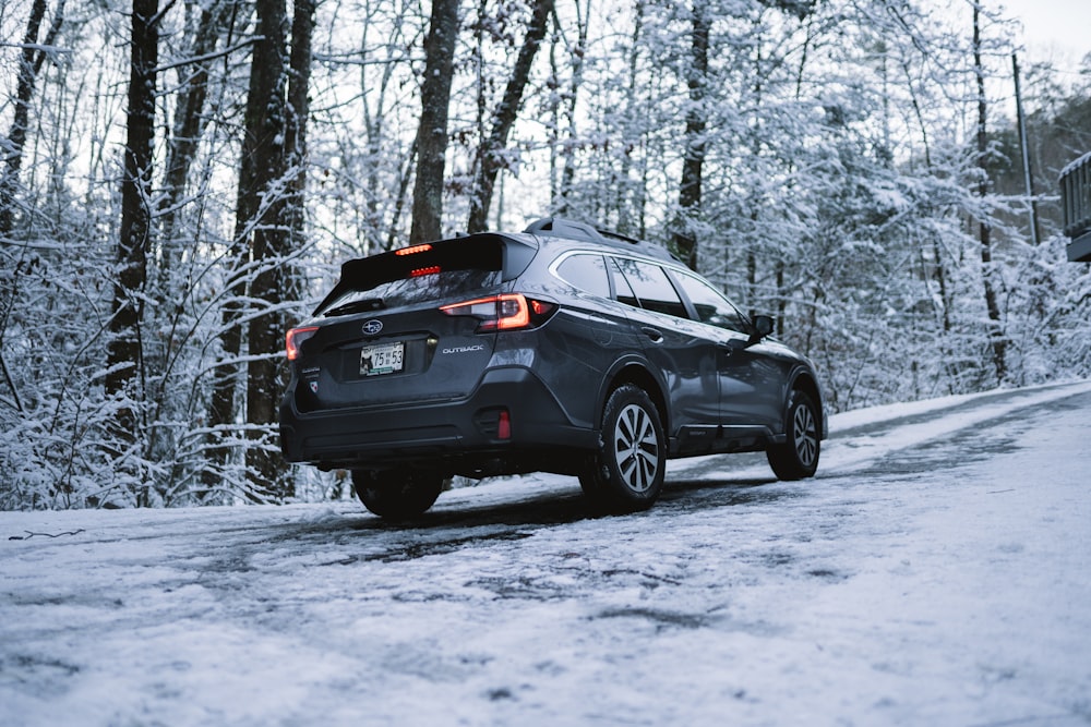 suv preto no chão coberto de neve durante o dia