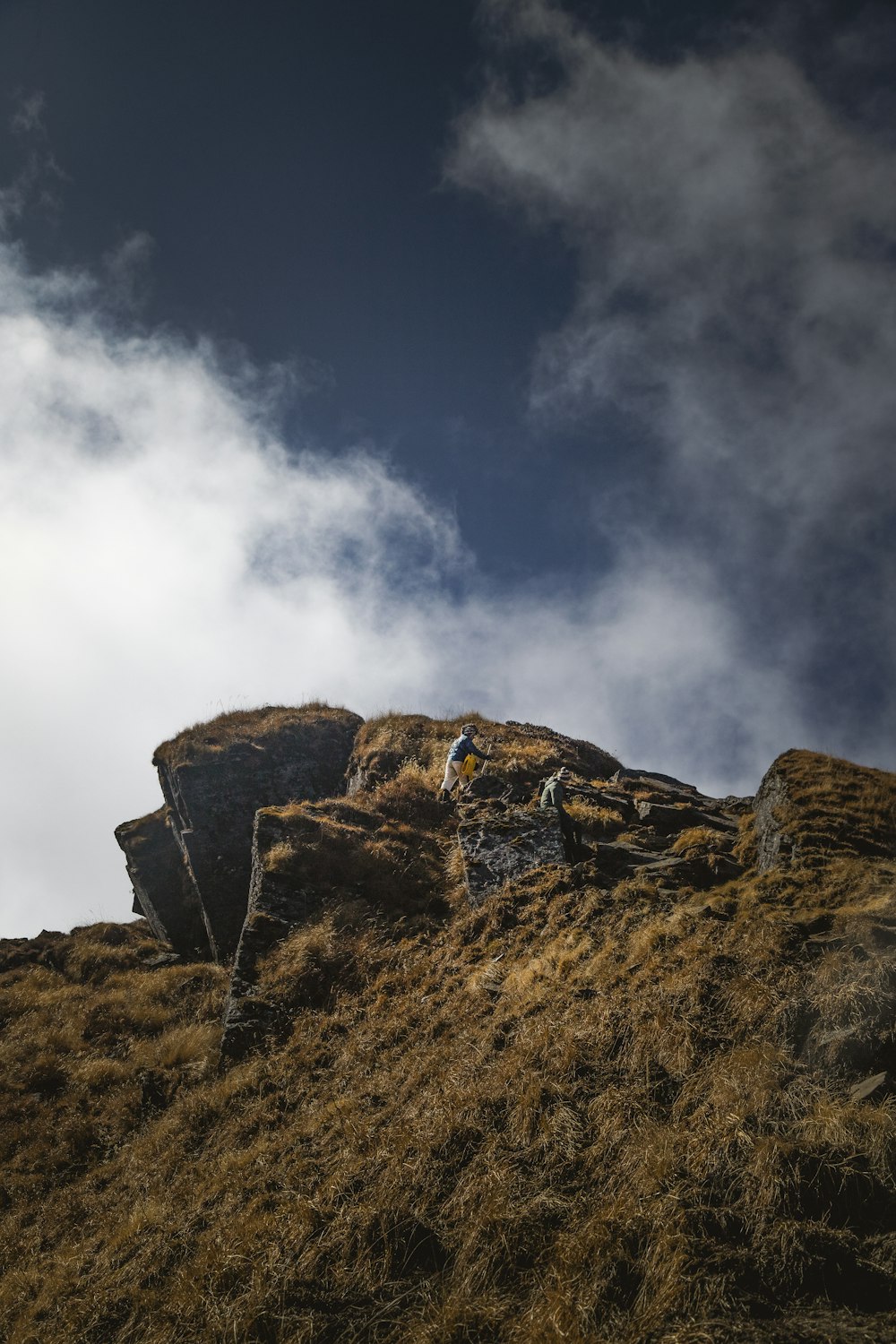 brown rock formation under white clouds