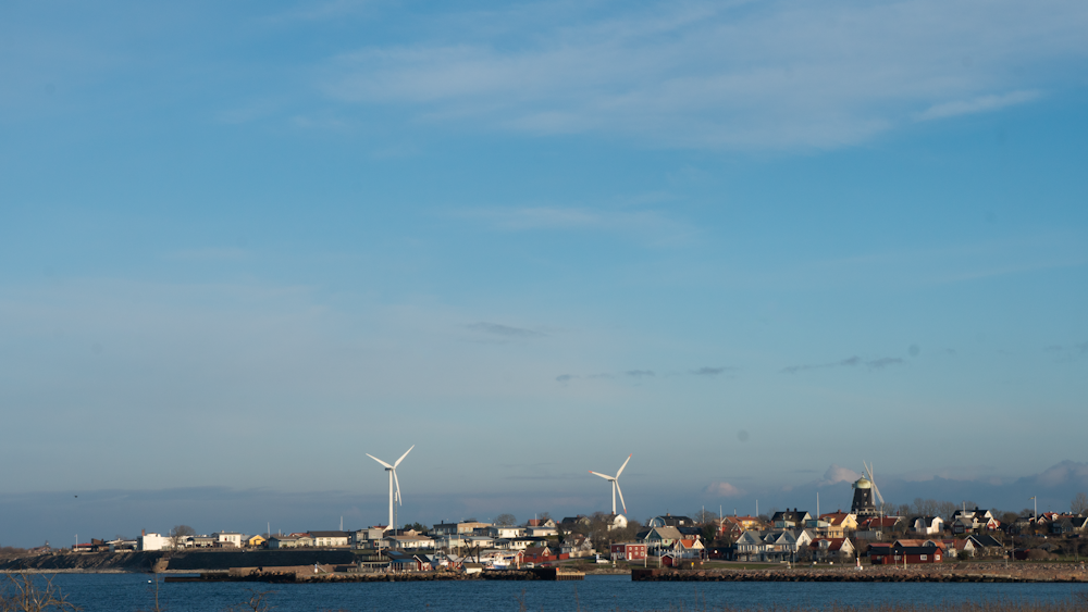 white wind turbines on city under blue sky during daytime