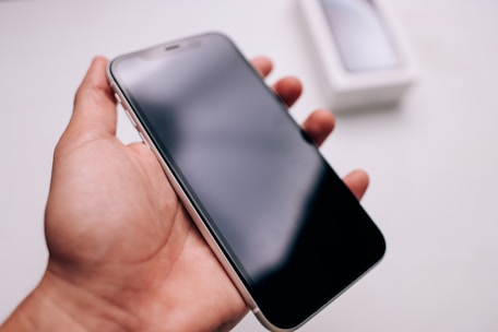 Close-up of a hand activating silent mode on a mobile phone.