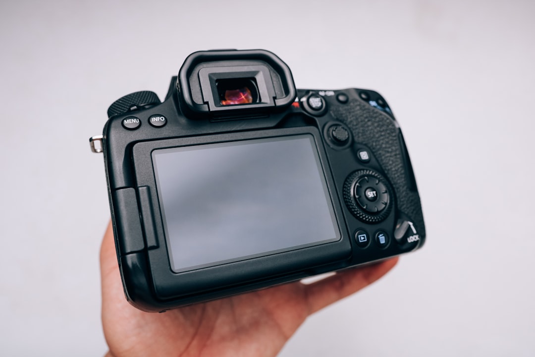 black dslr camera on persons hand
