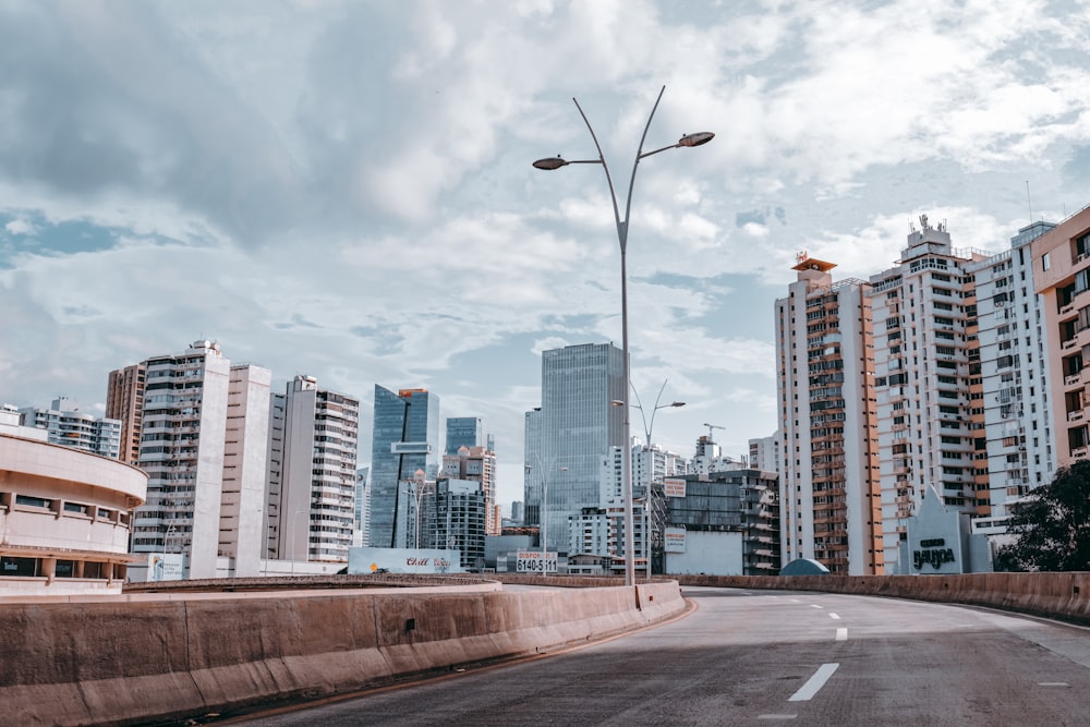 white and brown high rise buildings under white clouds during daytime