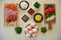 A colorful display of fresh ingredients laid out on a wooden table, ready for pizza making.