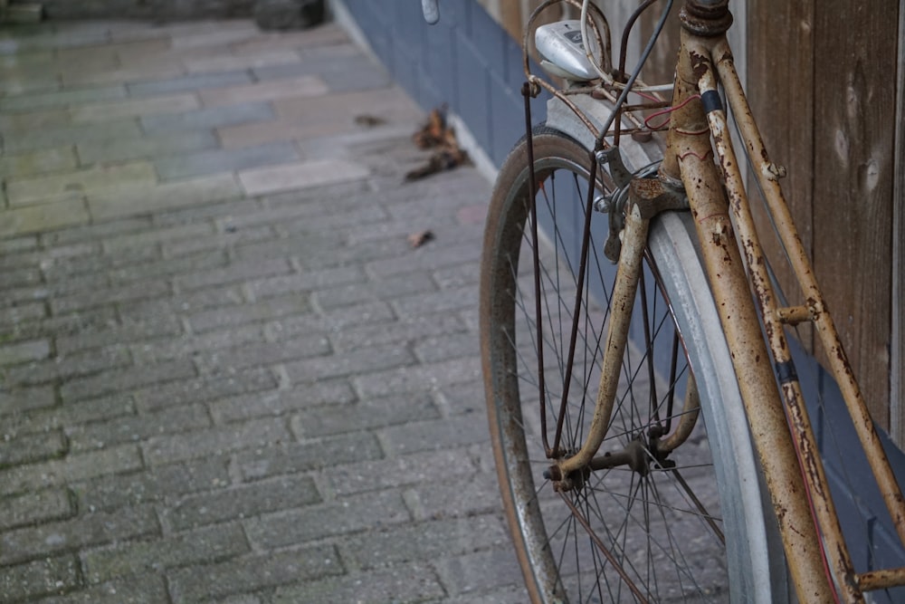 brown city bike parked on sidewalk during daytime