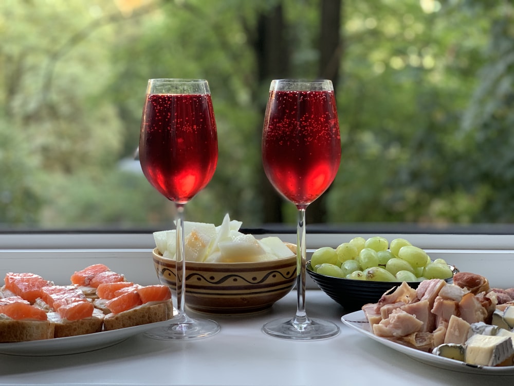 two wine glasses with red wine on table