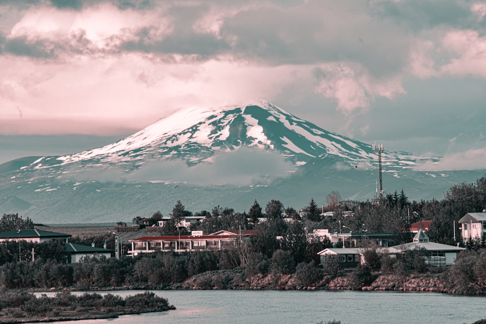 edificio blanco y rojo cerca de árboles verdes y montaña bajo nubes blancas durante el día