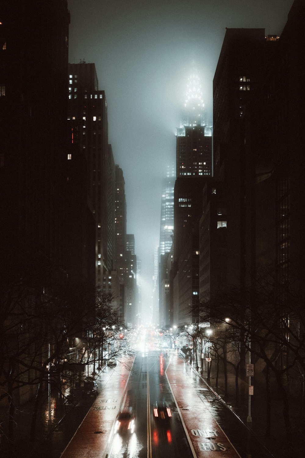 Coches en la carretera entre edificios de gran altura durante la noche