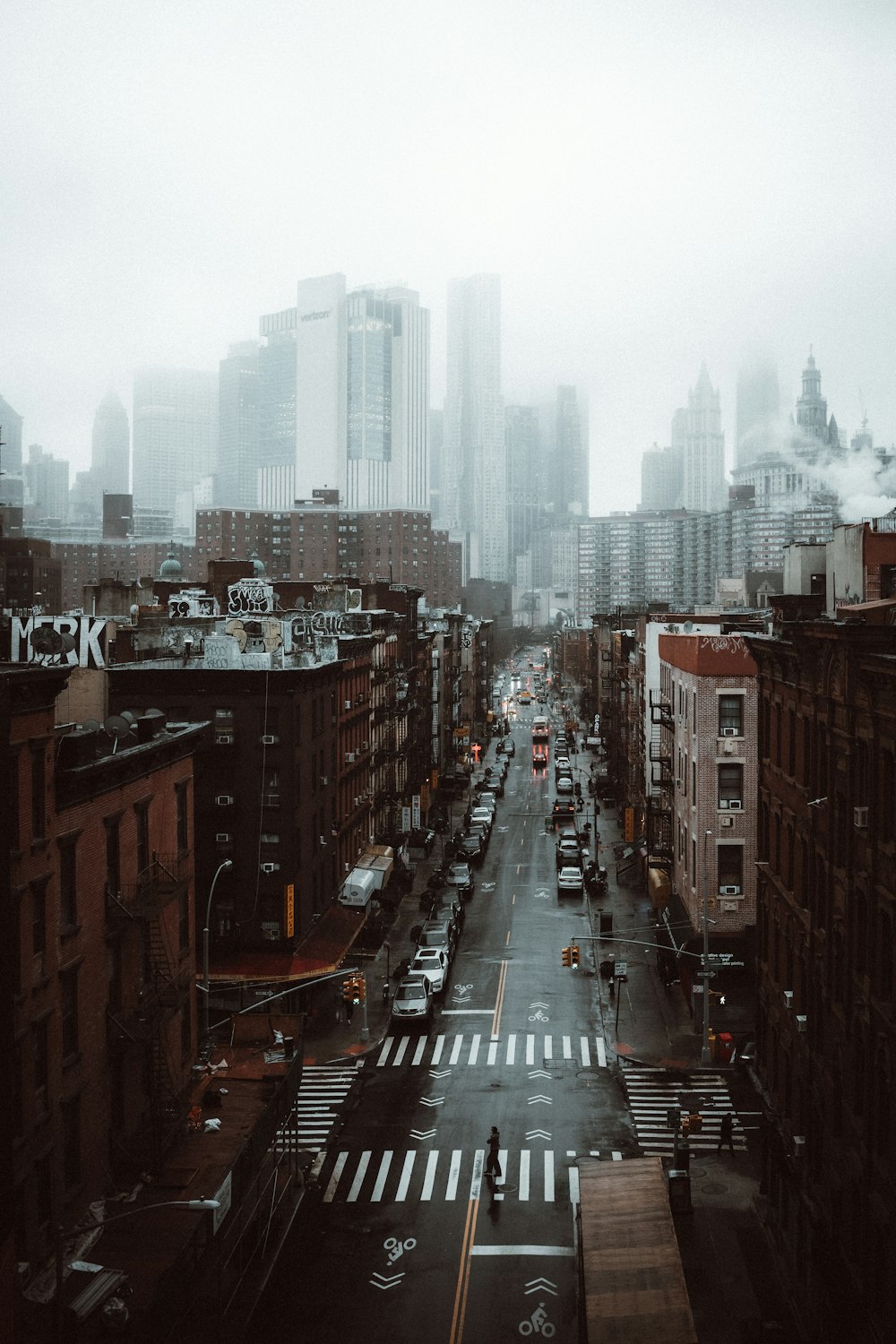 cars on road between high rise buildings during daytime