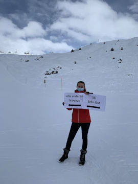 Instructor demonstrating avalanche beacon use on snowy mountain slope.