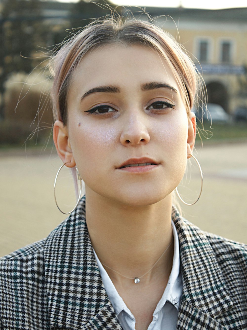 girl in black and white checkered shirt wearing white earbuds