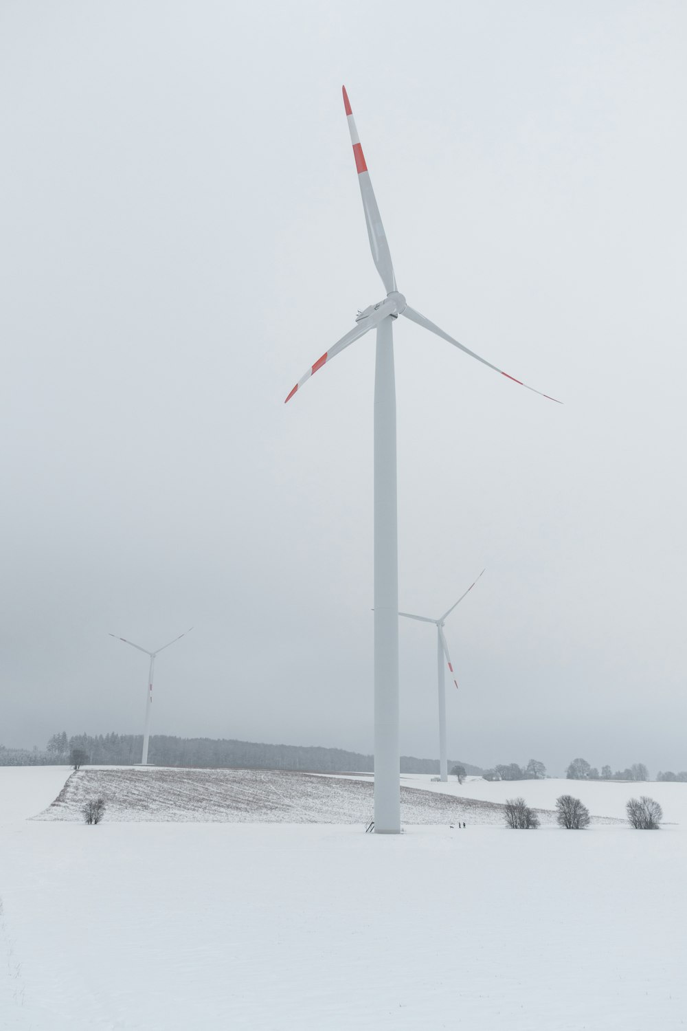 Turbina eólica blanca en suelo cubierto de nieve durante el día