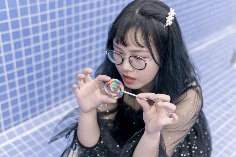 girl in white and black polka dot shirt holding white and pink bubble maker