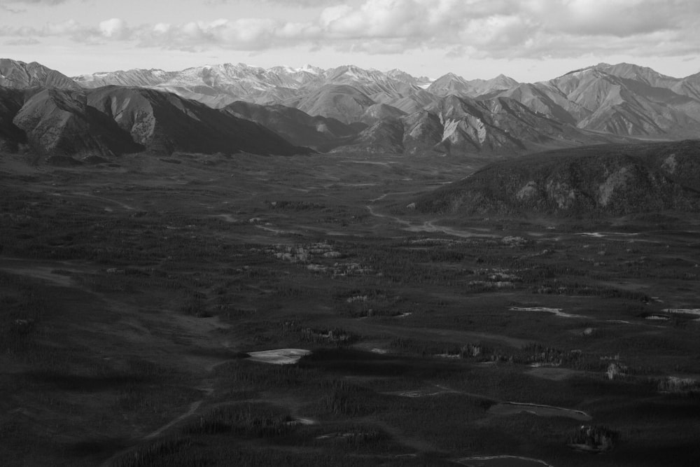 grayscale photo of mountains and clouds