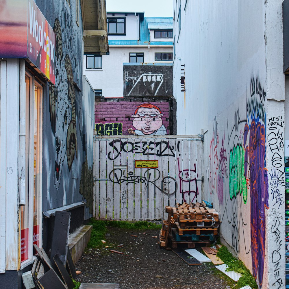 Banc en bois marron à côté d’un mur blanc avec des graffitis