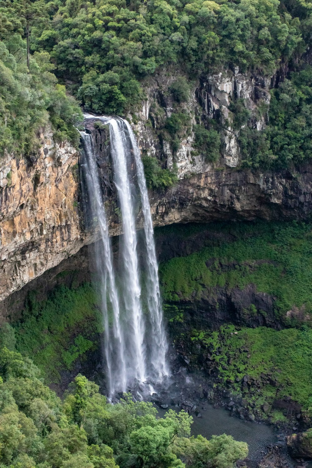 Chutes d’eau sur la montagne rocheuse brune pendant la journée