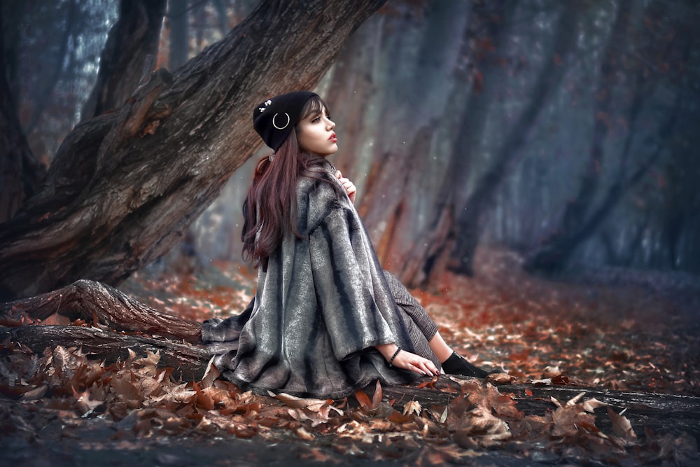 woman in black and white stripe dress sitting on dried leaves