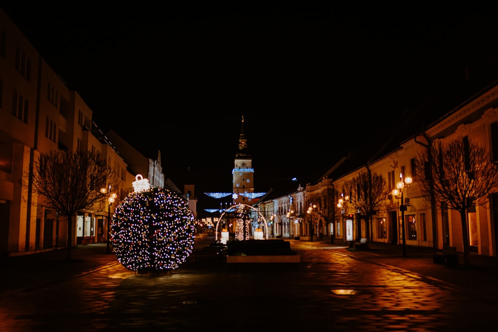 lighted white and yellow christmas tree in the middle of the city during night time