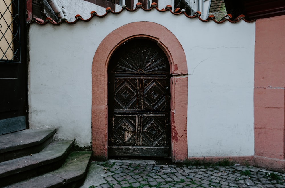 black wooden door on white and red concrete house