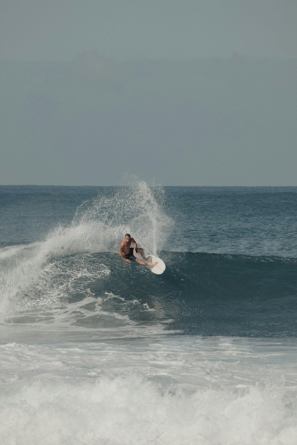 man surfing on sea waves during daytime