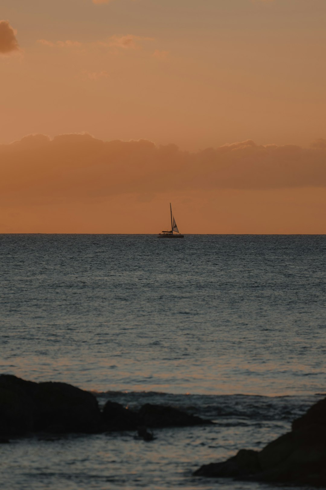 sailboat on sea during sunset