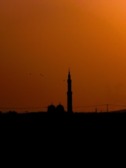 A serene mosque silhouette at sunset symbolizing faith and unity.