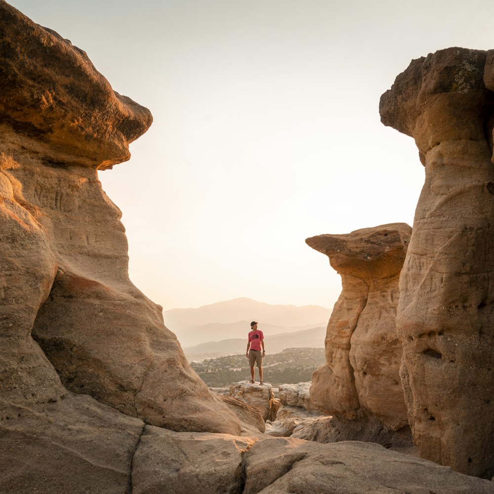 person standing on brown rock formation during daytime