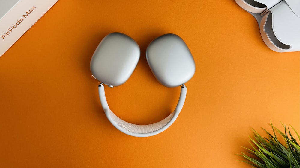 white and orange headphones on orange surface