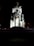 A monument featuring several sculpted busts arranged on cylindrical columns, illuminated dramatically against a dark background. The name 'Avram Iancu' is inscribed on the central structure. The lighting emphasizes the textures and details of the stone busts.
