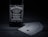 A bottle of Jack Daniel's Tennessee Whiskey displayed next to a spread of playing cards. The arrangement is set on a dark, wooden surface, accentuating the black and white label of the whiskey and the suits on the playing cards.