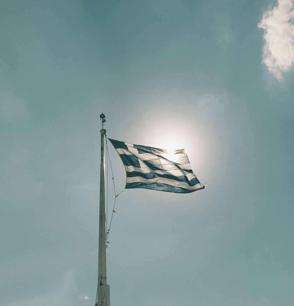 blue and white flag under cloudy sky