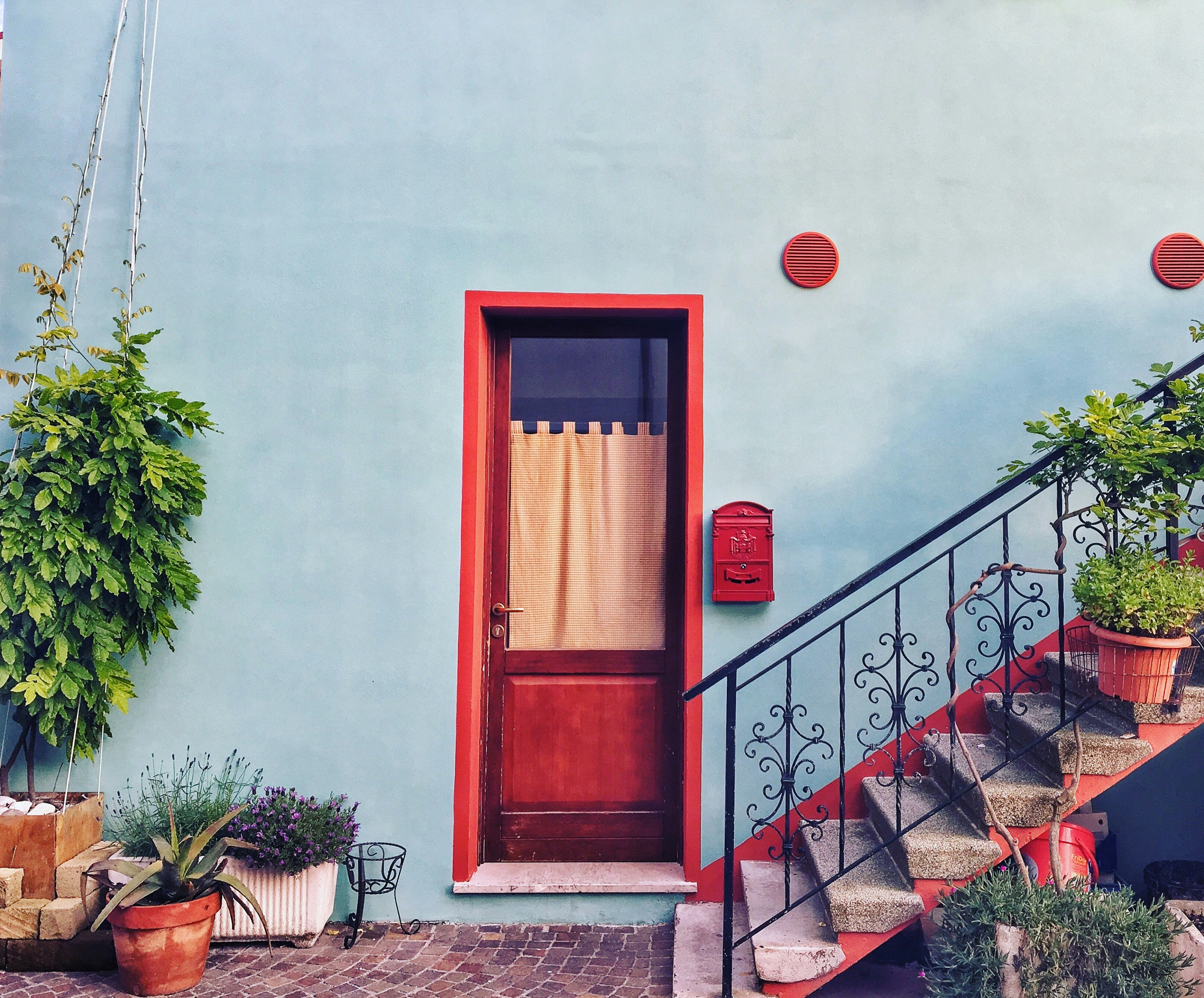 red round balloon on white concrete wall