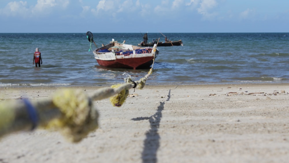 red and white boat on beach during daytime