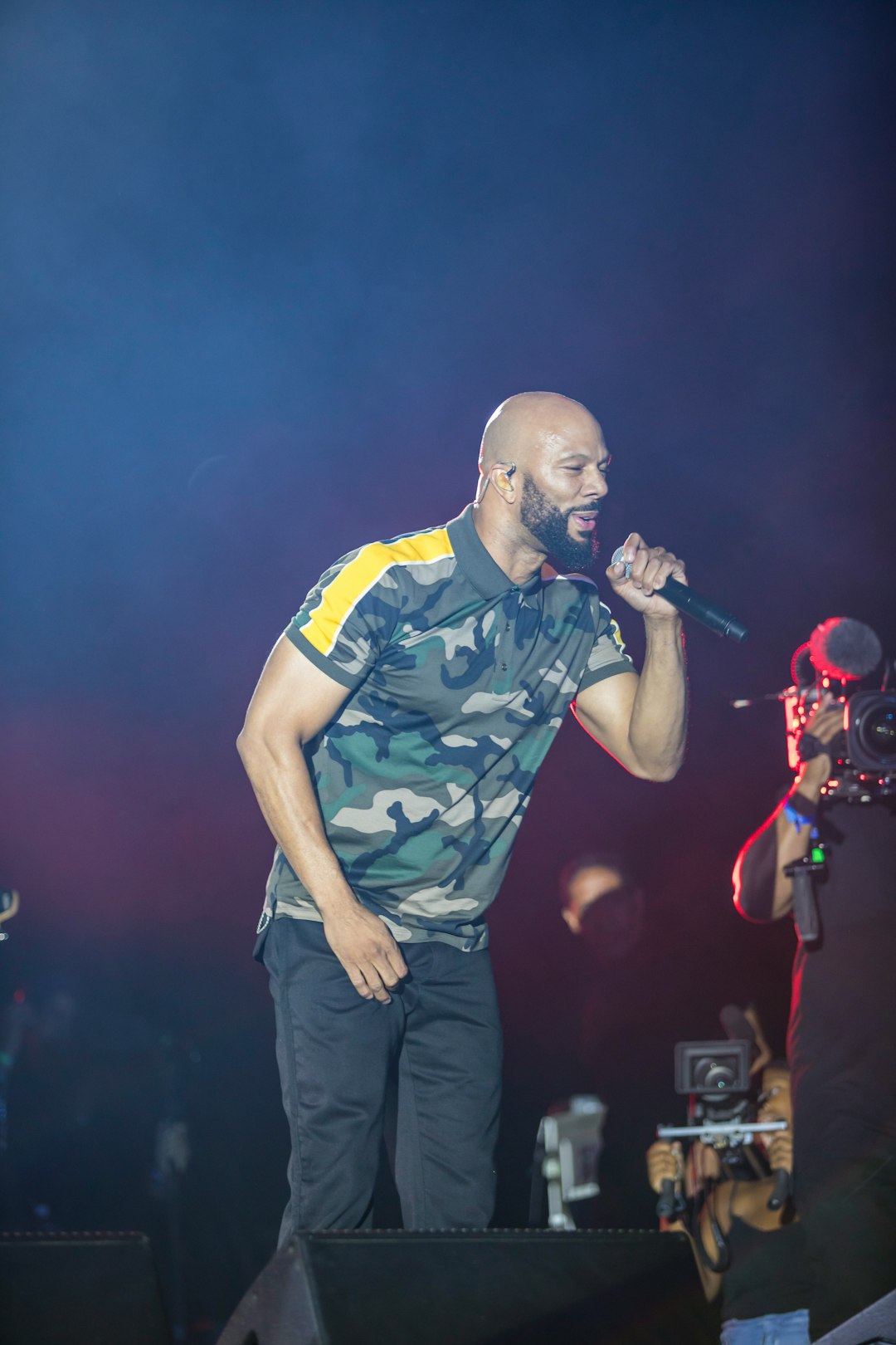 man in blue and white crew neck t-shirt singing