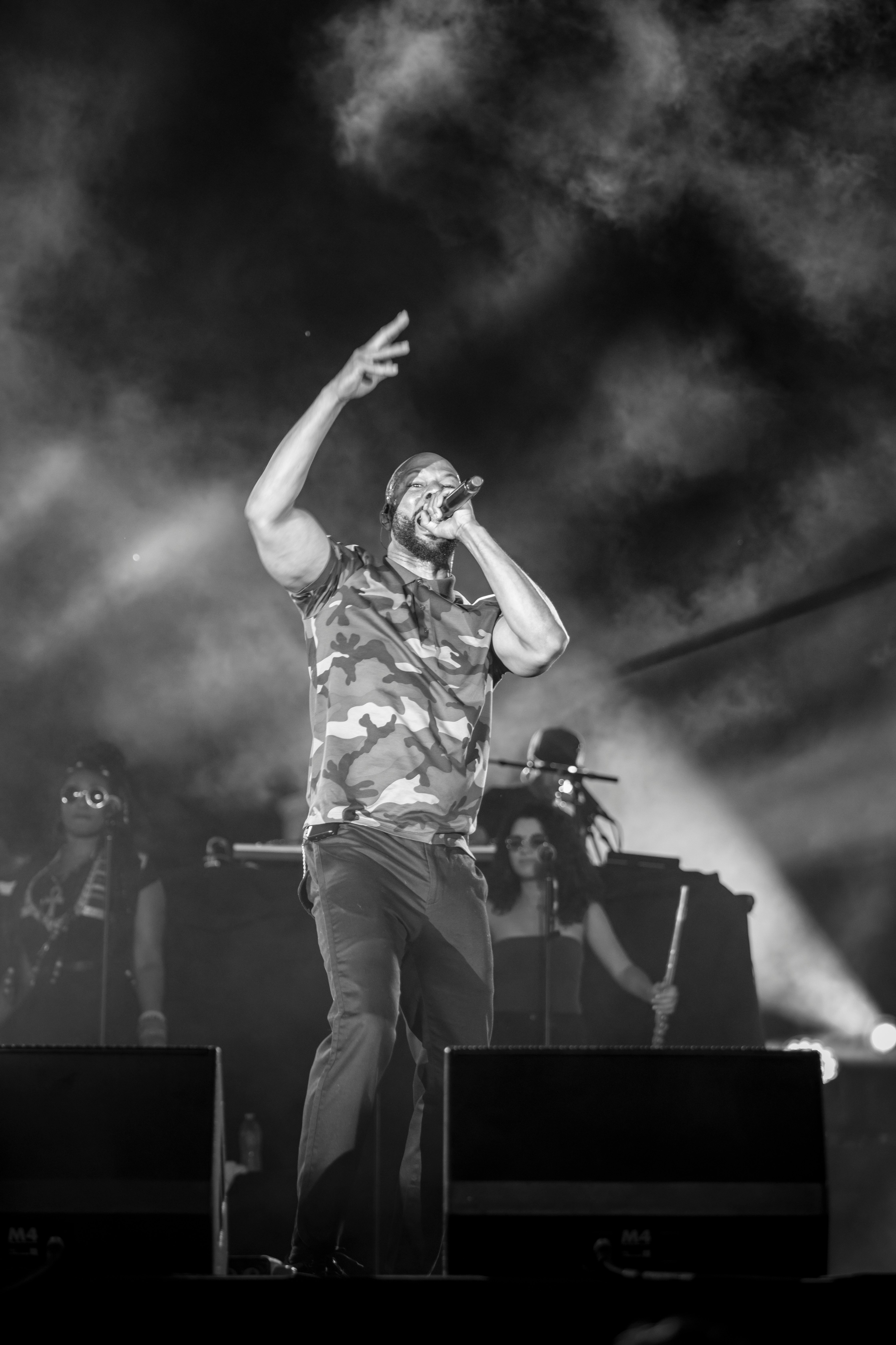 grayscale photo of man singing on stage