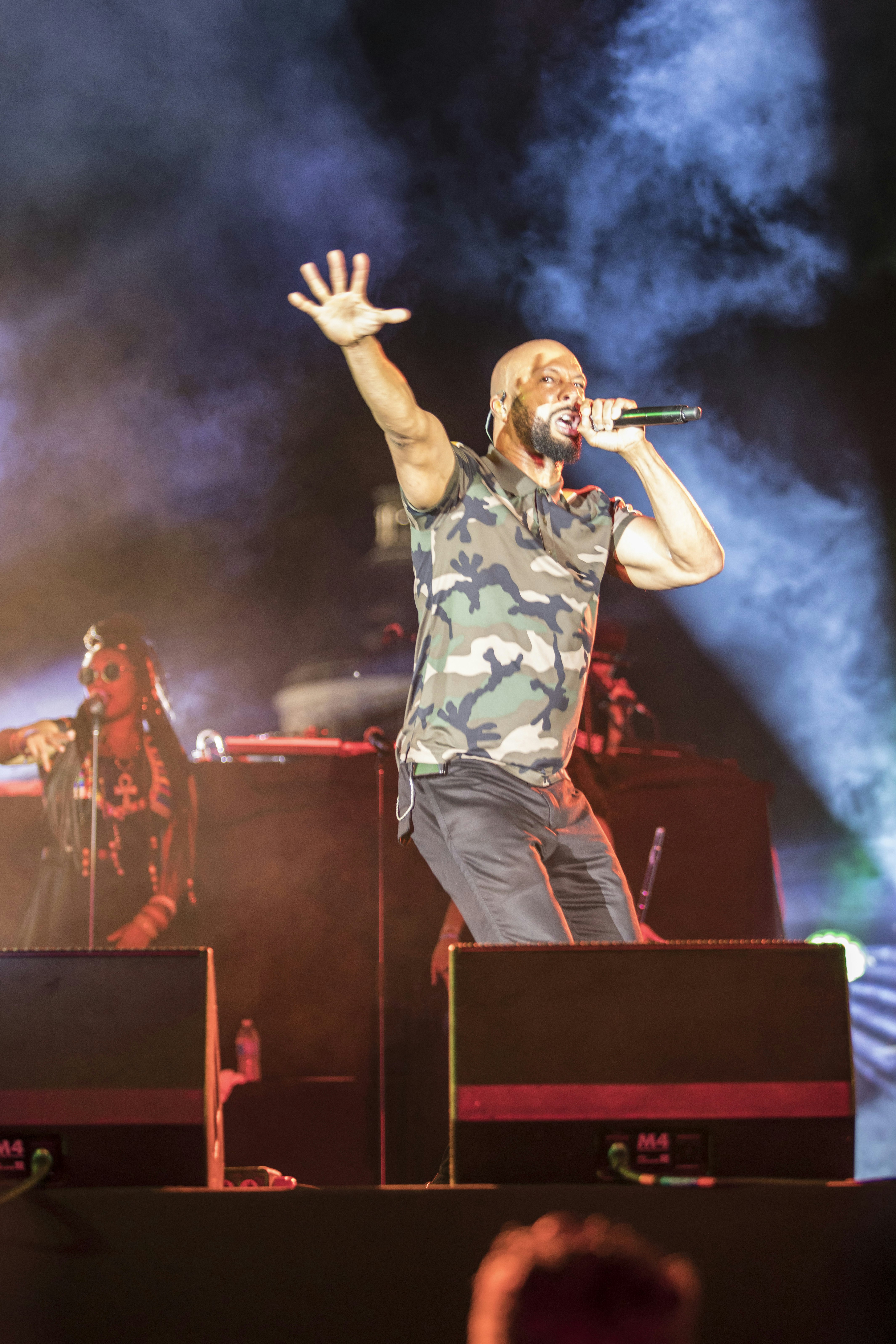 man in black and white floral shirt singing on stage