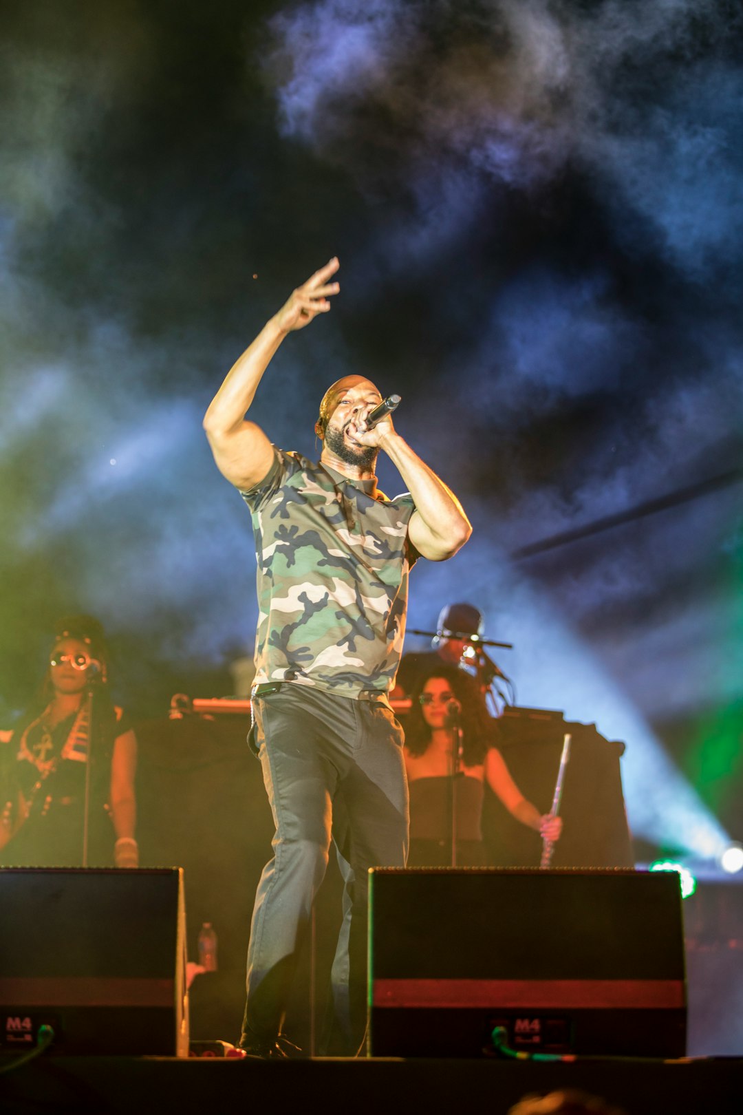 man in green and brown camouflage shirt singing on stage