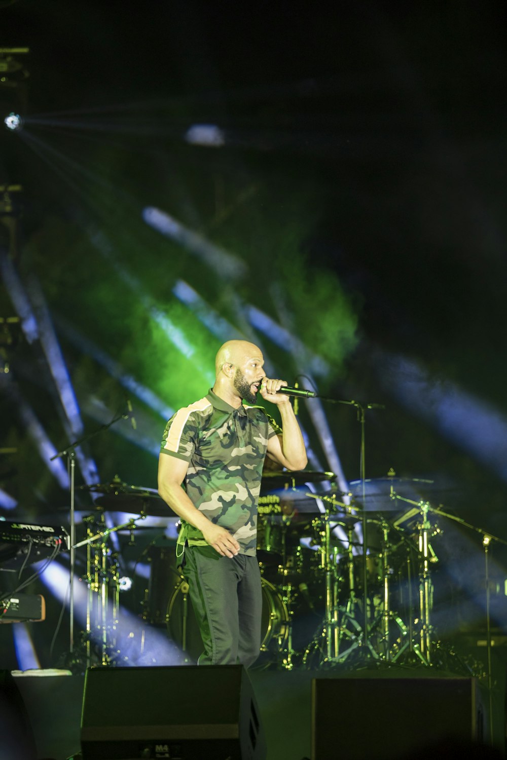 man in green polo shirt singing on stage