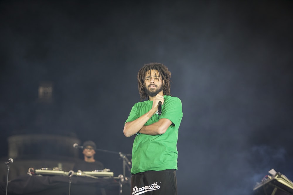 woman in green crew neck t-shirt and black shorts singing