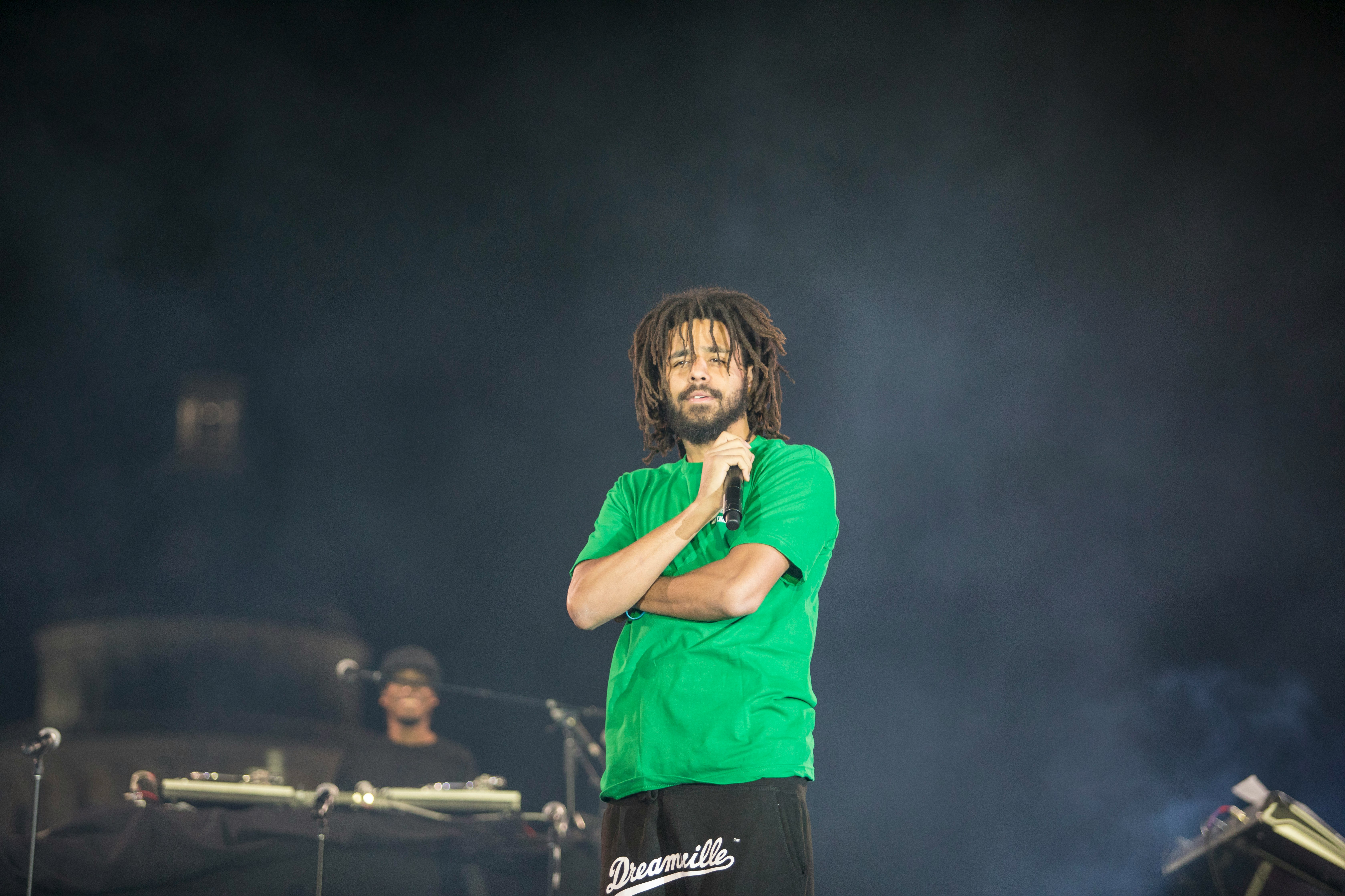 woman in green crew neck t-shirt and black shorts singing