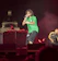 MC Flow performing energetically on stage with a vibrant crowd in the background.