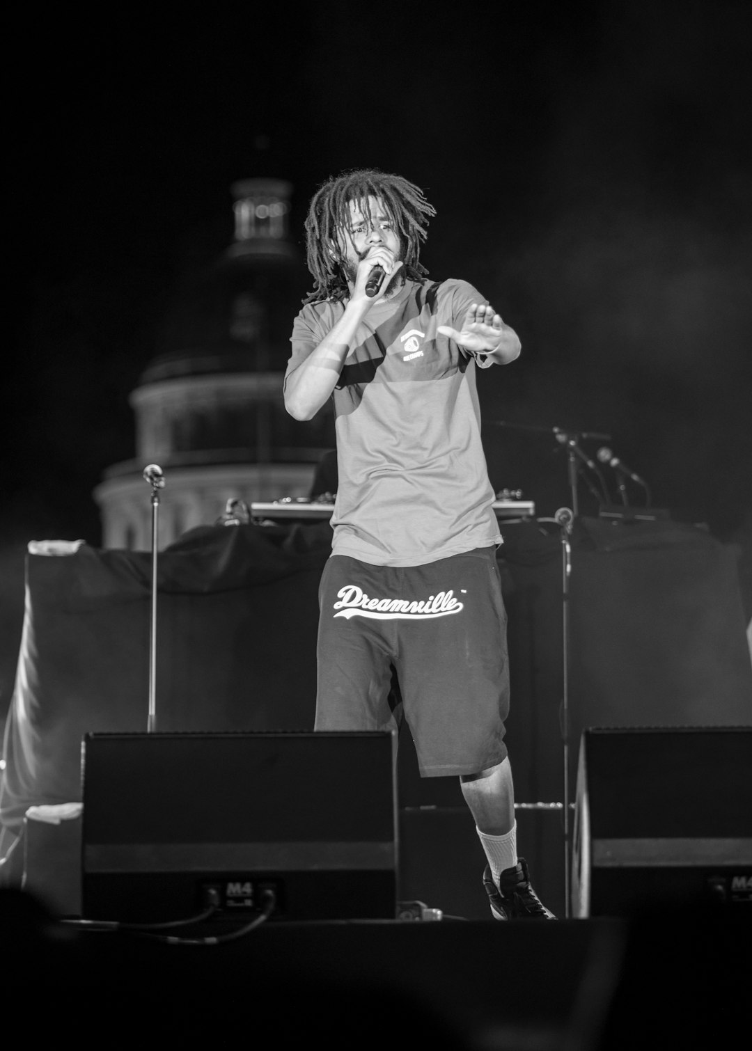 man in white crew neck t-shirt singing on stage