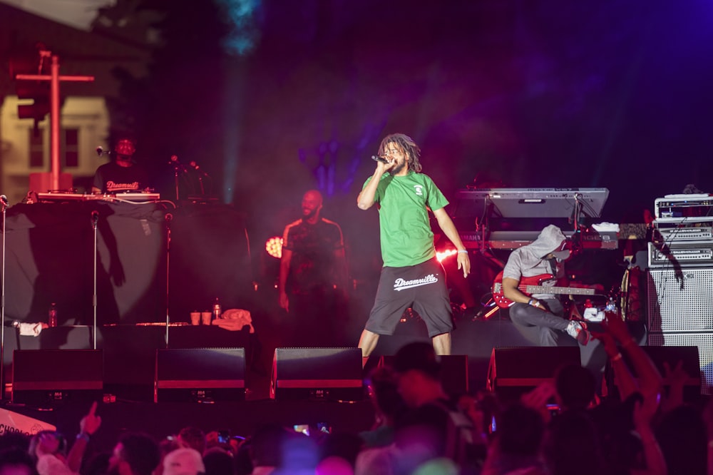 woman in green shirt singing on stage