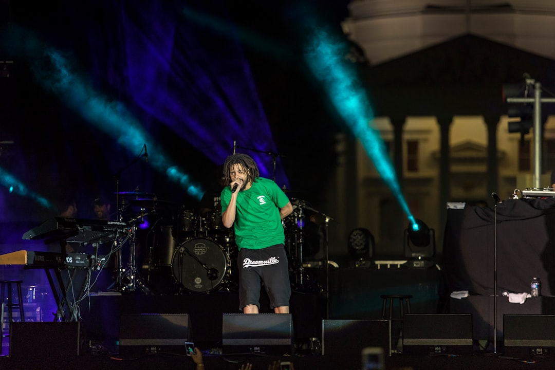 man in green t-shirt singing on stage