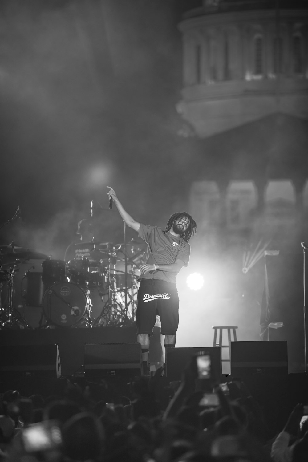 man in black helmet and white shirt playing guitar on stage