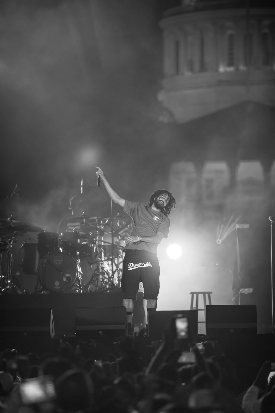 man in black helmet and white shirt playing guitar on stage