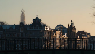 A vibrant European cityscape showing historic buildings and lively streets during sunset.