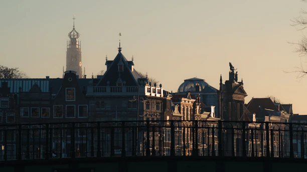 A vibrant European cityscape showing historic buildings and lively streets during sunset.
